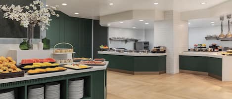 Een buffet met verschillende soorten eten en een bloevas.