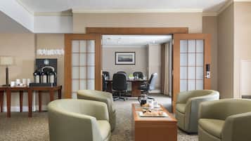 Une chambre d’hôtel dotée d’un coin salon, d’un espace pour préparer du café et donnant sur le couloir.