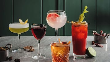 Four different cocktails on a marble surface with a green background.