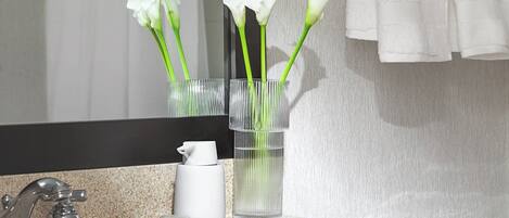 Un baño con lavabo, espejo y barra para toallas.