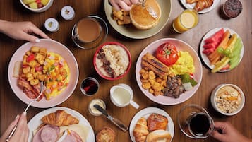 A table with various breakfast items including eggs, toast, fruits, and beverages.