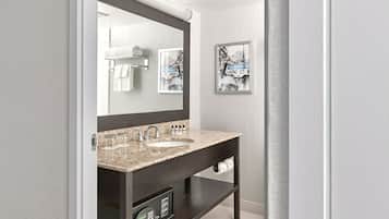 A modern bathroom with a dark vanity, two sinks, a large mirror, and a framed picture on the wall.