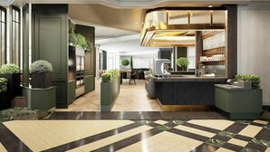 A modern hotel lobby with a central reception desk, seating area, and a large window. - Chelsea Hotel, Toronto (Toronto)