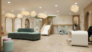 A children's play area with a slide, seating, and a reception desk. - Chelsea Hotel, Toronto (Toronto)