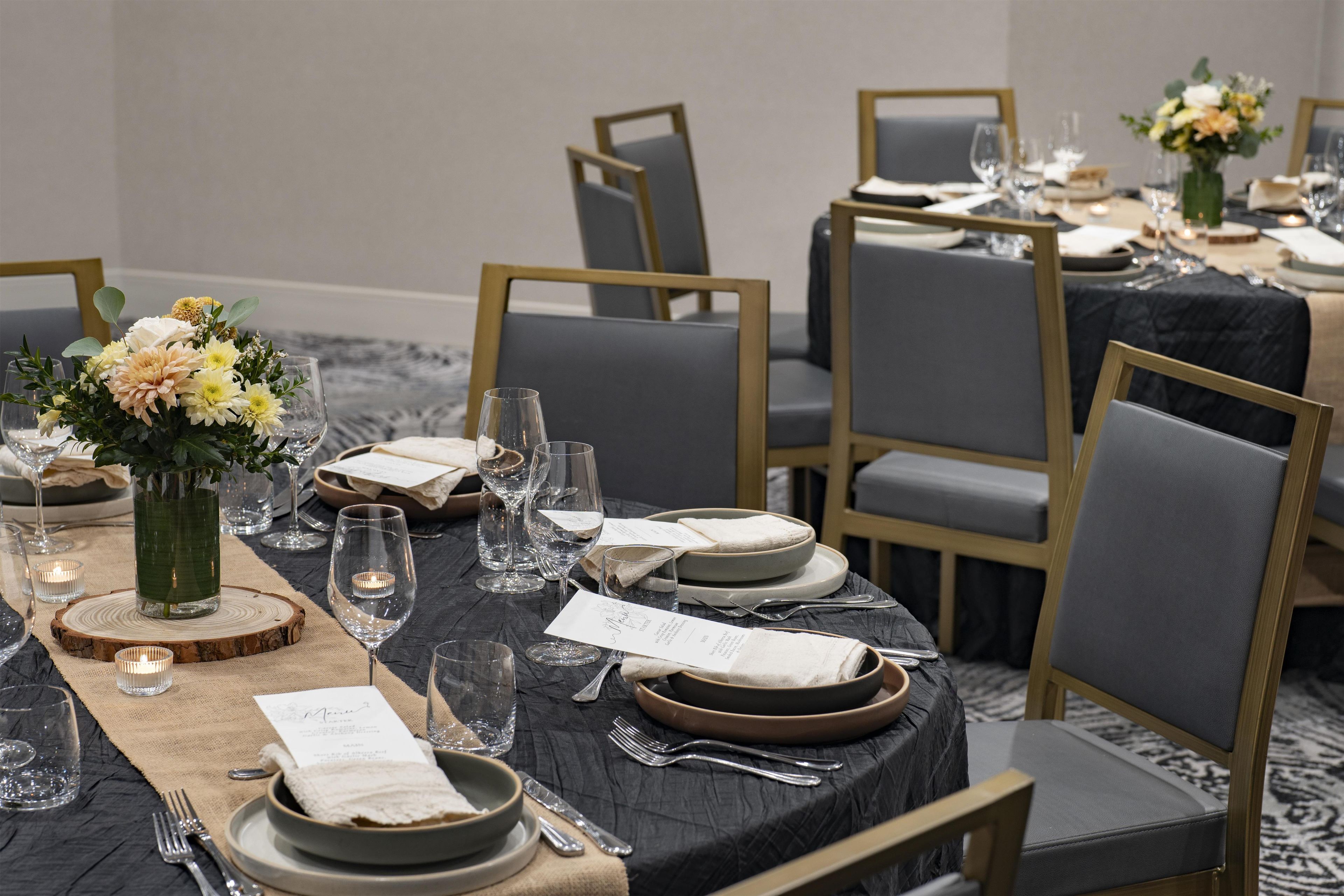 A formal dining setup with multiple tables, chairs, and a menu.