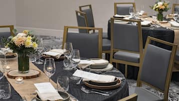 A formal dining setup with multiple tables, chairs, and a menu.