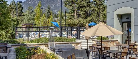 An outdoor patio with seating, a pool, and mountain views.