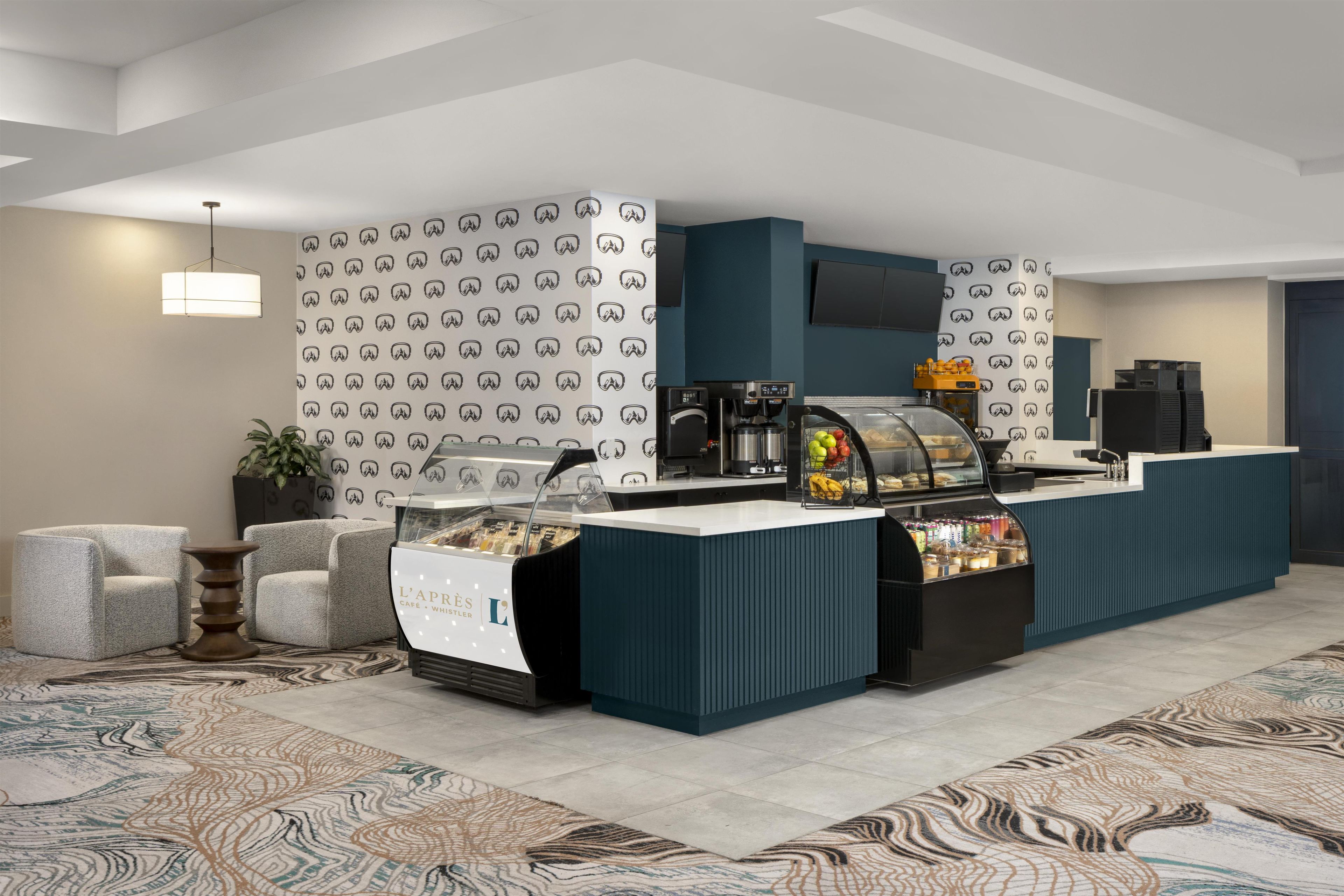 Una moderna hall d'albergo con scrivania della reception, area salotto e angolo caffè.
