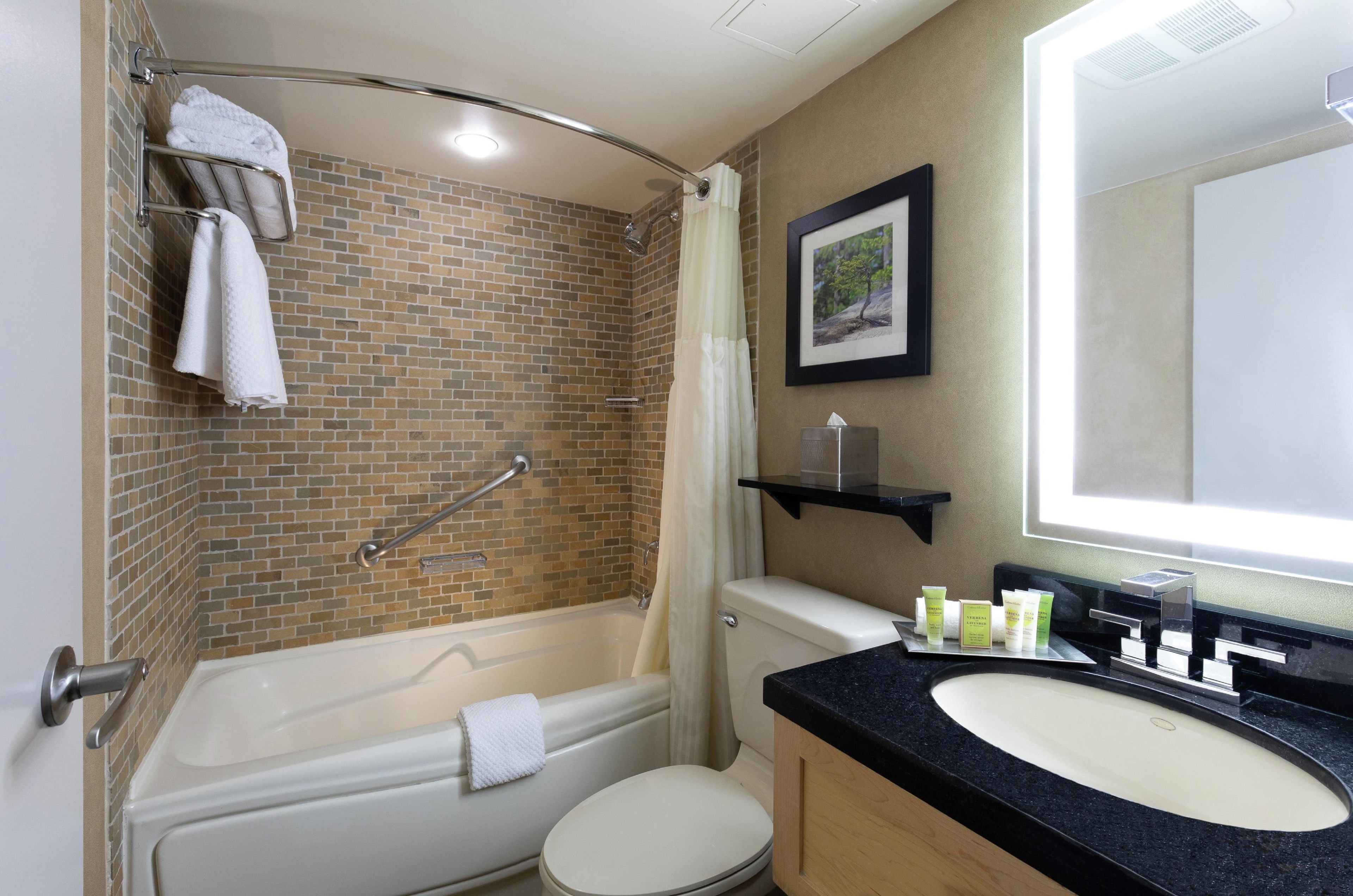 A bathroom with a bathtub, toilet, and sink.