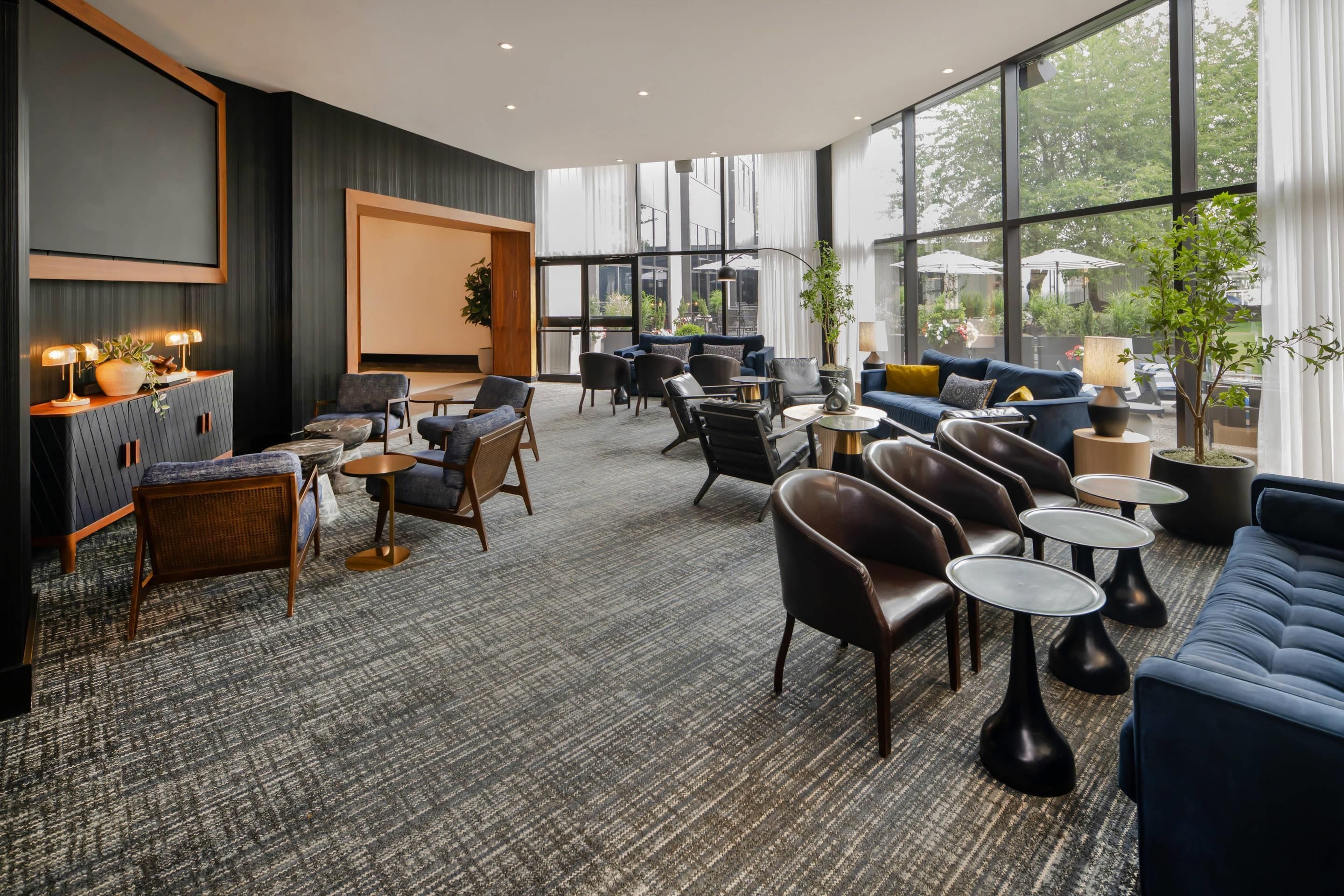 Een moderne zithoek met diverse zitplaatsen, waaronder banken, stoelen en tafels.