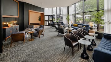 A modern lounge area with a mix of seating options, including sofas, chairs, and tables.