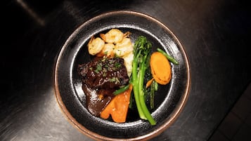 A plate of food with shrimp, beef, and vegetables.