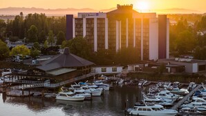 Un puerto deportivo con barcos amarrados, un edificio con la señalización 'Rollins' y una puesta de sol al fondo.