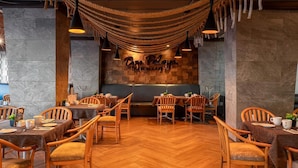 A restaurant interior with wooden flooring, round tables, and chairs. - Don Pelayo Pacific Beach (Mazatlán)