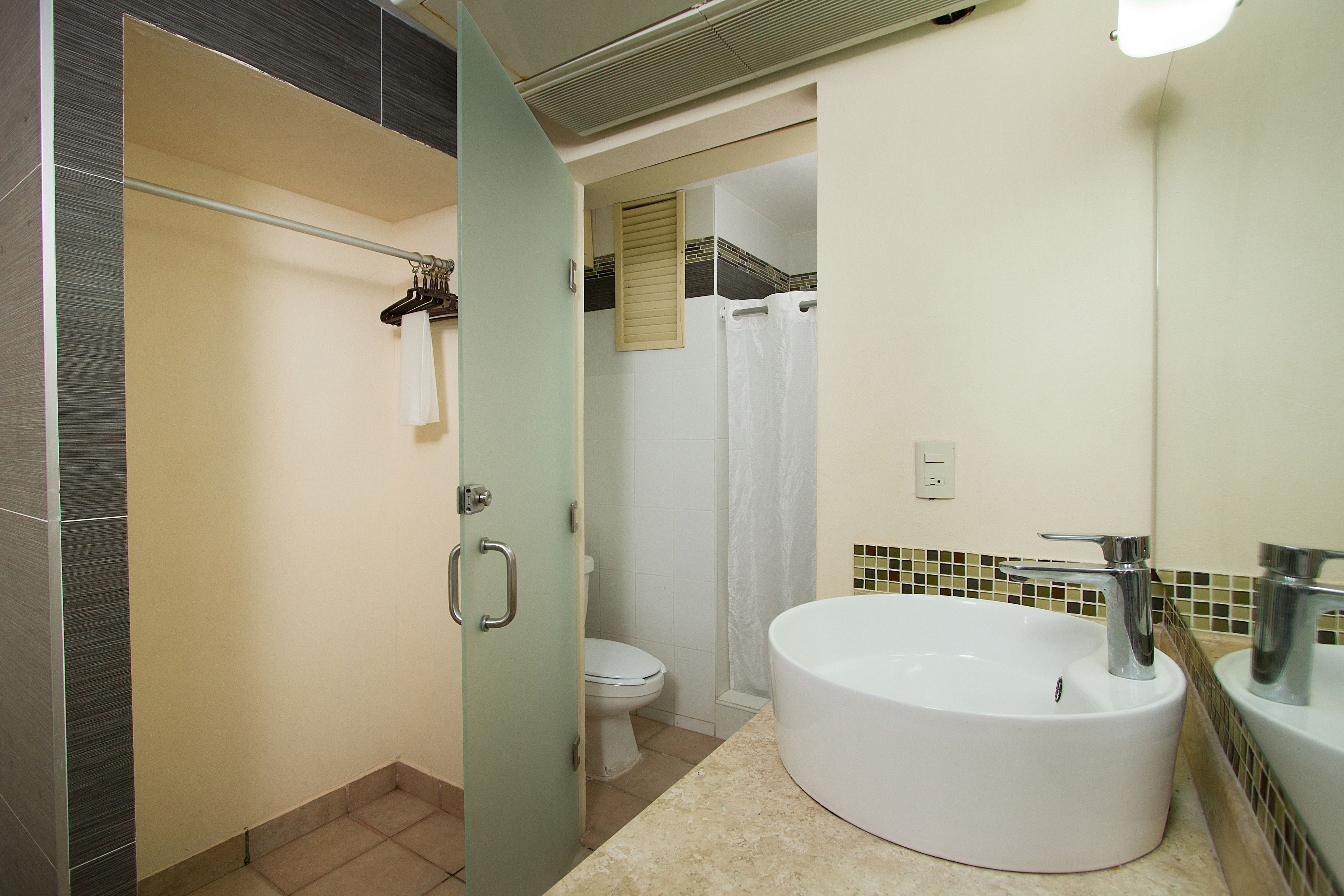 Un baño con una bañera grande, un inodoro y una cortina de ducha.