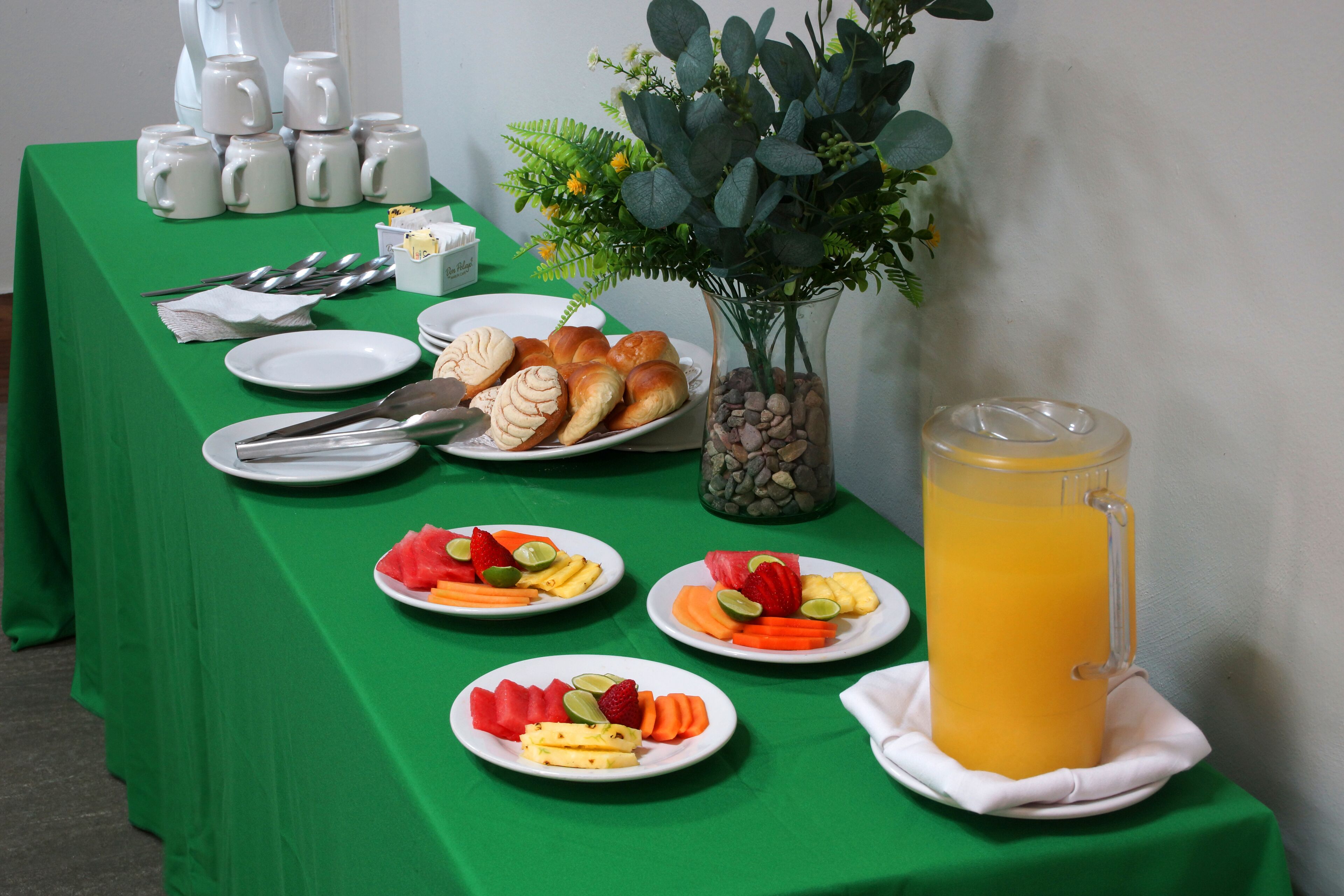 Buffet de l'esmorzar amb diversos aliments i una gerra de suc d'aranja.