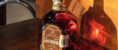En flaska Los Osuna Extra Anejo-tequila står på ett träbord.