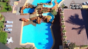 A swimming pool with a unique rock formation and a water slide. - Don Pelayo Pacific Beach (Mazatlán)