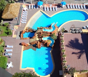 A swimming pool with a unique rock formation and a water slide. - Don Pelayo Pacific Beach (Mazatlán)