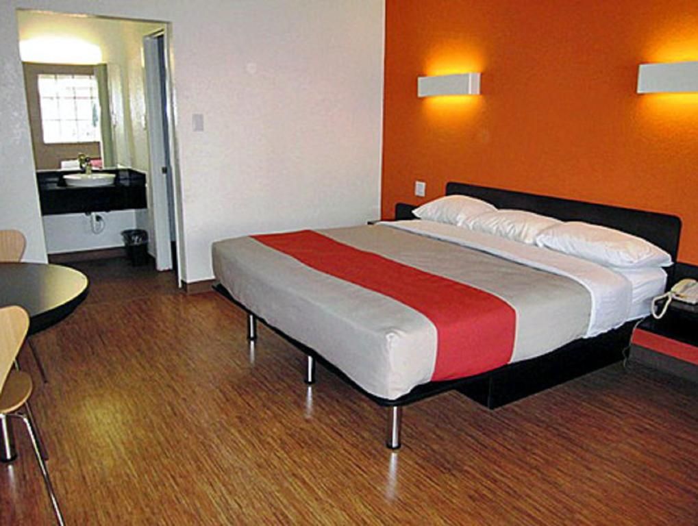 A hotel room with a bed, a desk, and a chair.