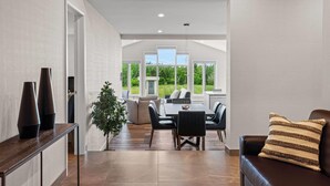 A modern interior with a dining area, a sofa, and a view of the outdoors. - Days Inn by Wyndham Riviere-Du-Loup (Rivière-du-Loup)