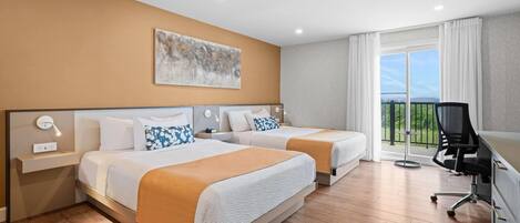 Habitación de hotel con dos camas, un escritorio y vistas al exterior.