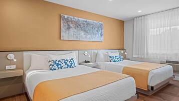 A hotel room with two beds, a large abstract painting on the wall, and a window with sheer curtains.