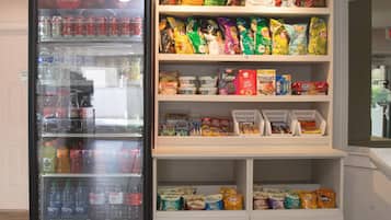 Un distributeur automatique rempli de boissons et d’en-cas, notamment des chips Lay’s et des glaces Fudge.