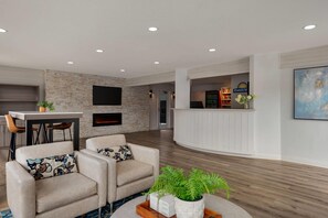 A modern hotel lobby with a fireplace, seating area, and a reception desk. - Days Inn by Wyndham Kelowna (Kelowna)