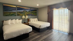 A hotel room with two beds, a nightstand with a lamp, a painting on the wall, and a large window with curtains. - Days Inn by Wyndham Medford (Medford)