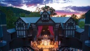 A theater with a stage, audience seating, and a backdrop of trees and a sunset. - Days Inn by Wyndham Medford (Medford)