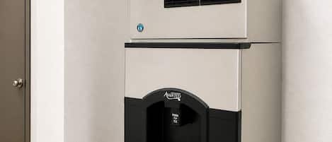 A commercial kitchen with a branded ice dispenser and a ventilation system.
