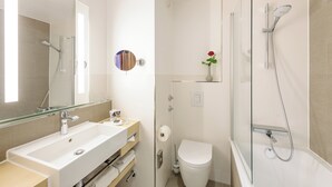 A modern bathroom with a large sink, toilet, and glass-enclosed shower. - Mercure Hotel Erfurt Altstadt (Erfurt)