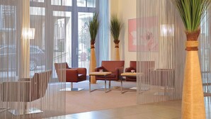 Un hall d’entrée moderne avec un espace salon, de grandes fenêtres et des plantes décoratives.