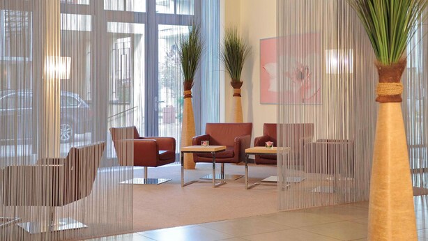 A modern lobby with a seating area, large windows, and decorative plants. - Mercure Hotel Erfurt Altstadt (Erfurt)