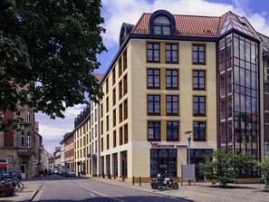 A hotel with a yellow facade, multiple windows, and a red-tiled roof. - Mercure Hotel Erfurt Altstadt (Erfurt)