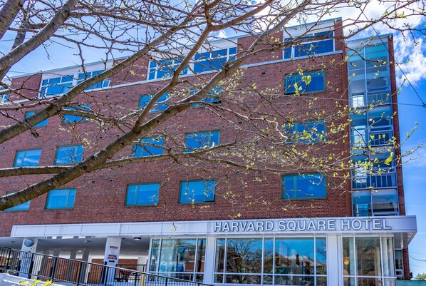 Hotel Harvard Square, con fachada de ladrillo y grandes ventanales.