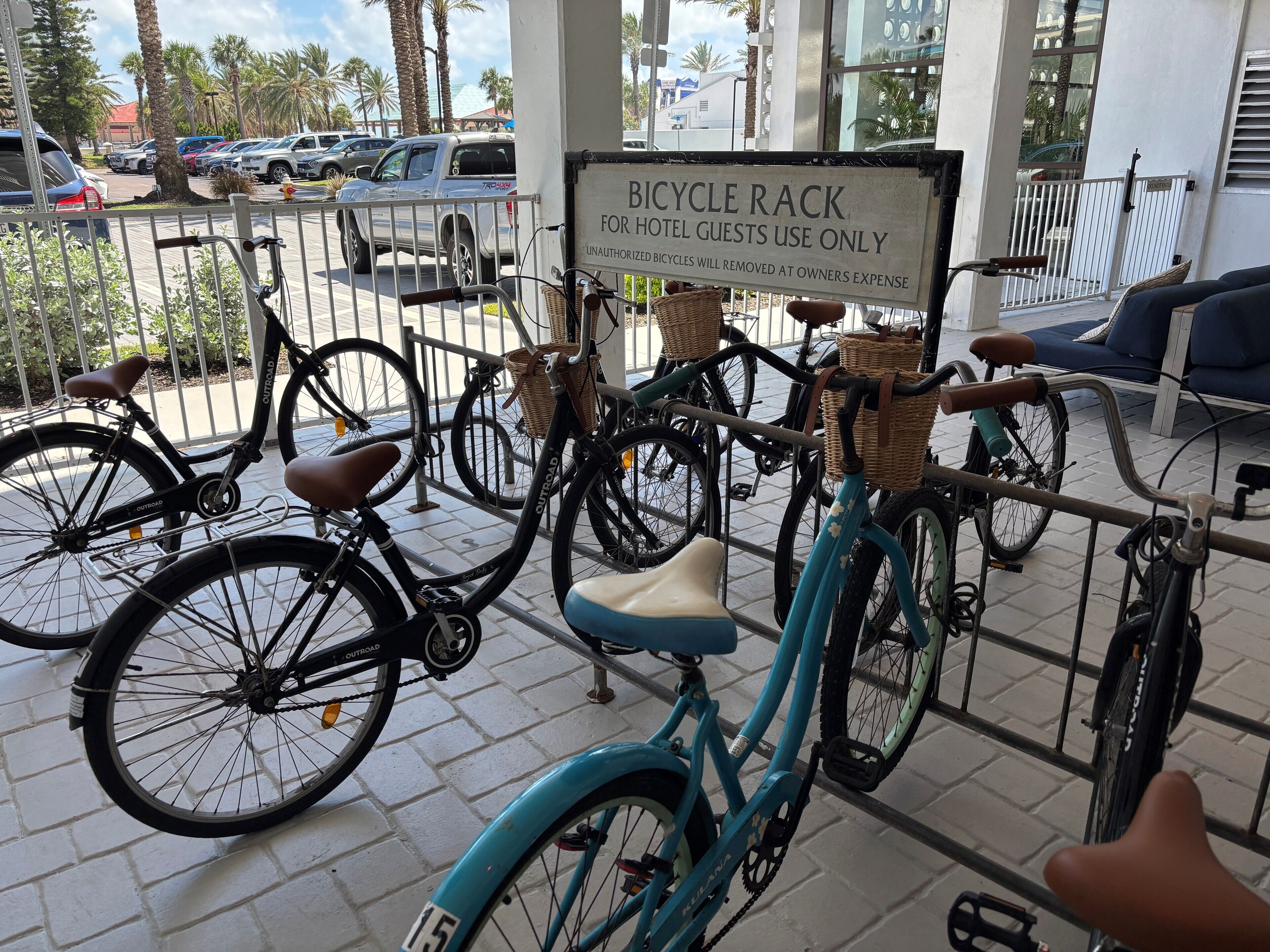 Suporte de bicicletas com placa indicando uso exclusivo para hóspedes do hotel.