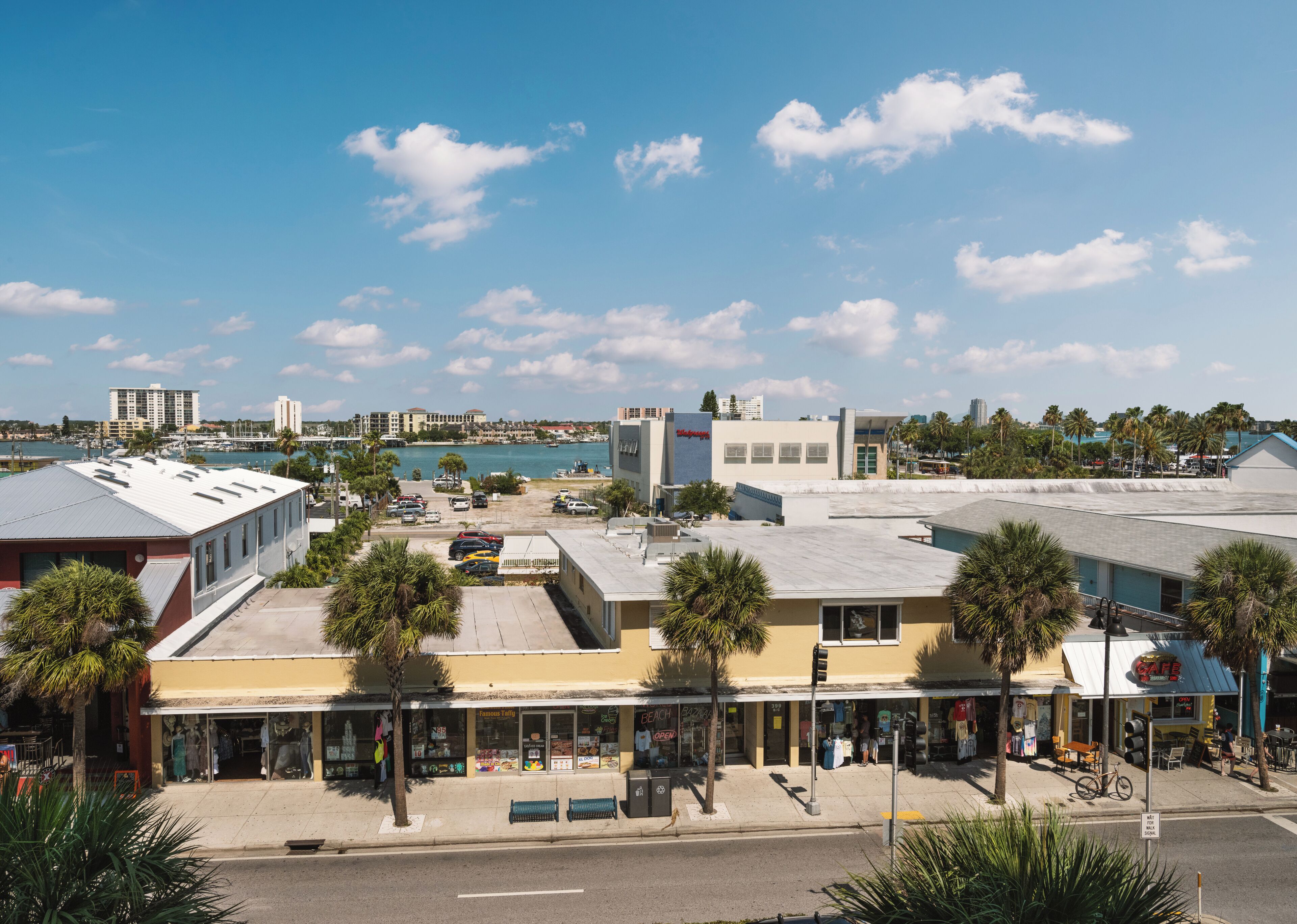 Une ville côtière dotée d’un port de plaisance, de bâtiments et de palmiers.