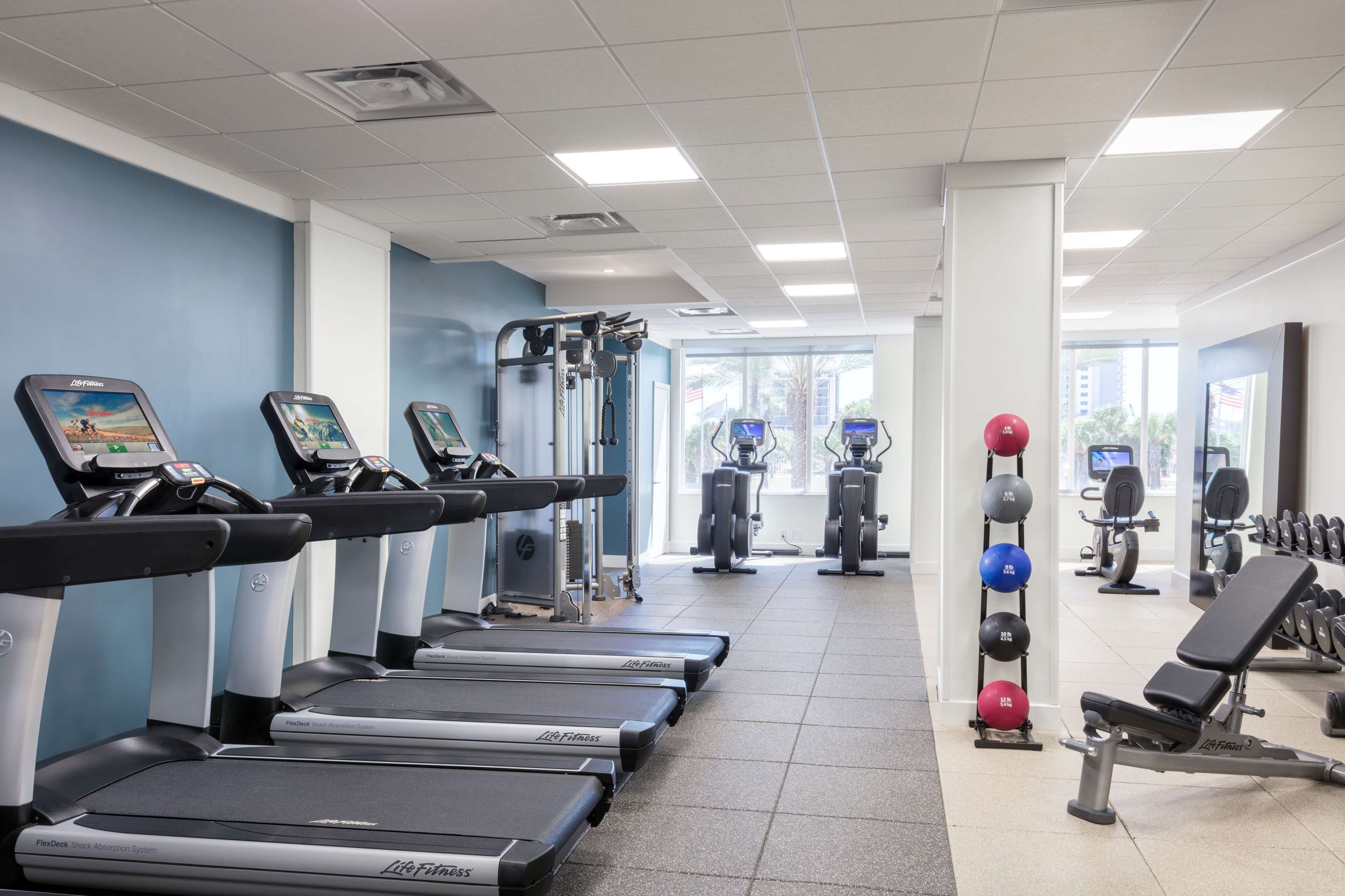 A gym with treadmills, elliptical machines, and weightlifting equipment.