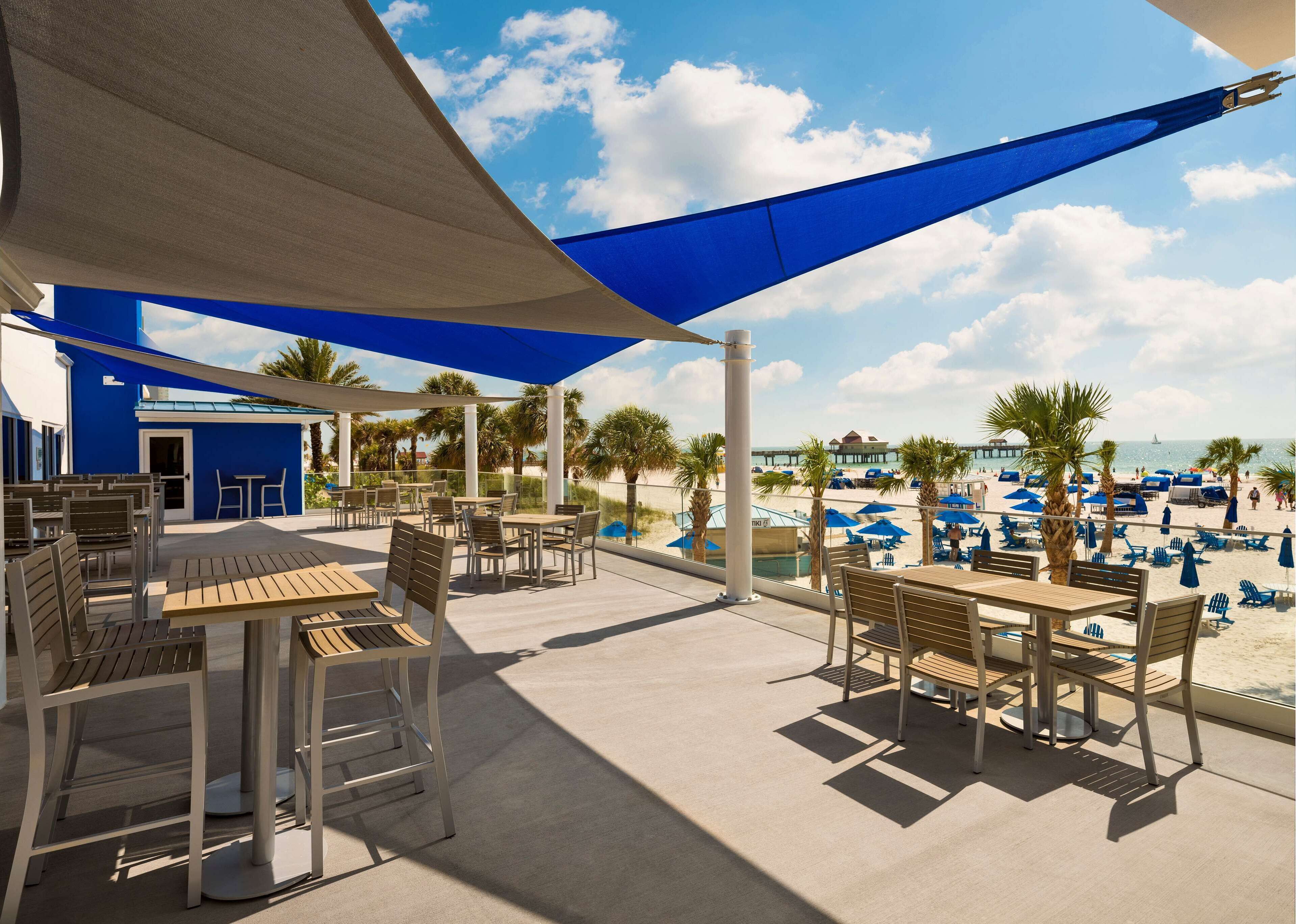 Un patio frente a la playa con mobiliario exterior y vista al mar.