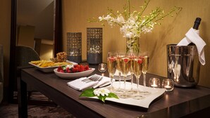 A well-set dining table with a champagne bottle, glasses, and a fruit bowl. - The Westin Tysons Corner (Falls Church)