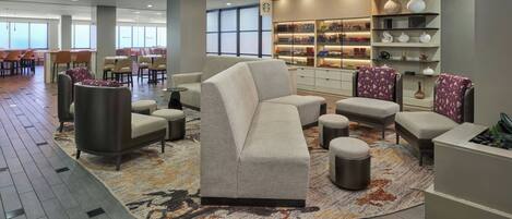 A modern lounge area with seating, a fireplace, and a display of decorative items.