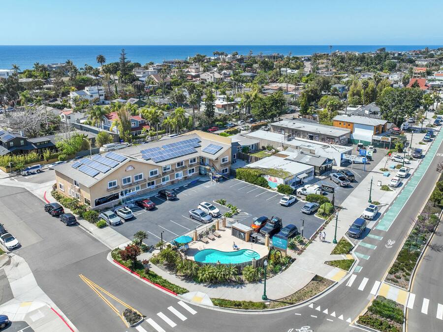 Ein Hotel mit Schwimmbad, Solaranlage und Parkplatz.