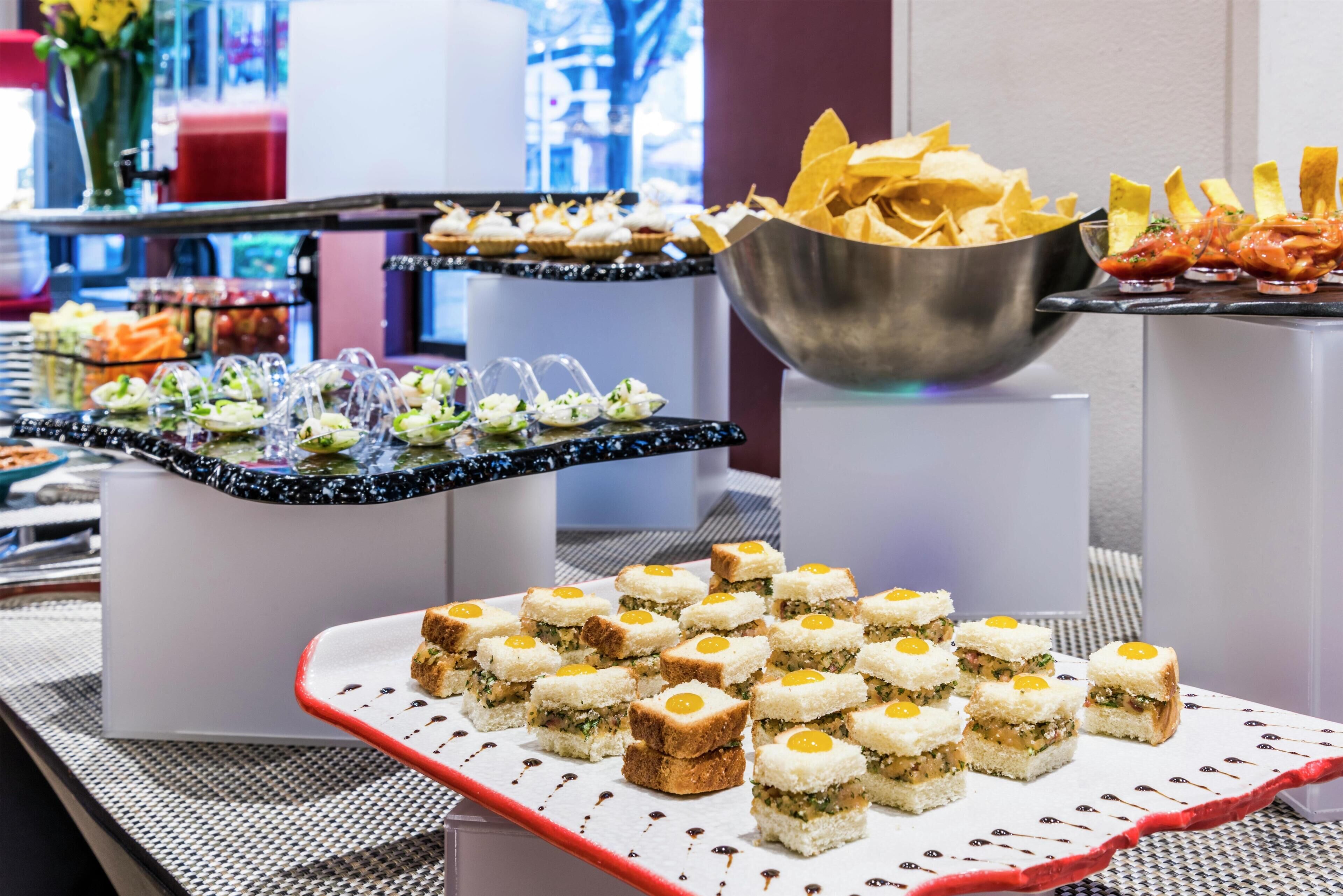 A buffet with various food items, including sandwiches, chips, and appetizers.