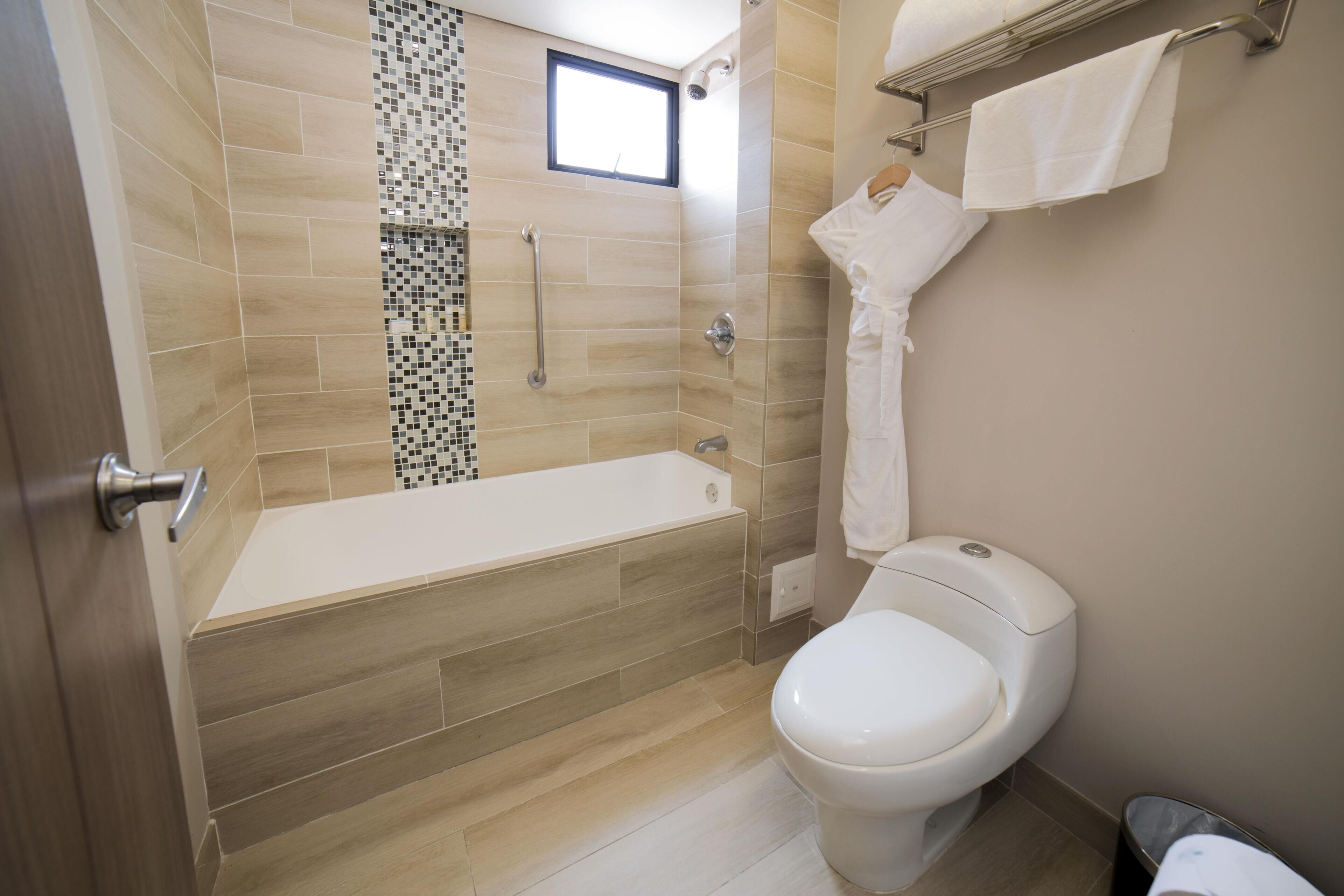 Een moderne badkamer met bad, toilet en douche.