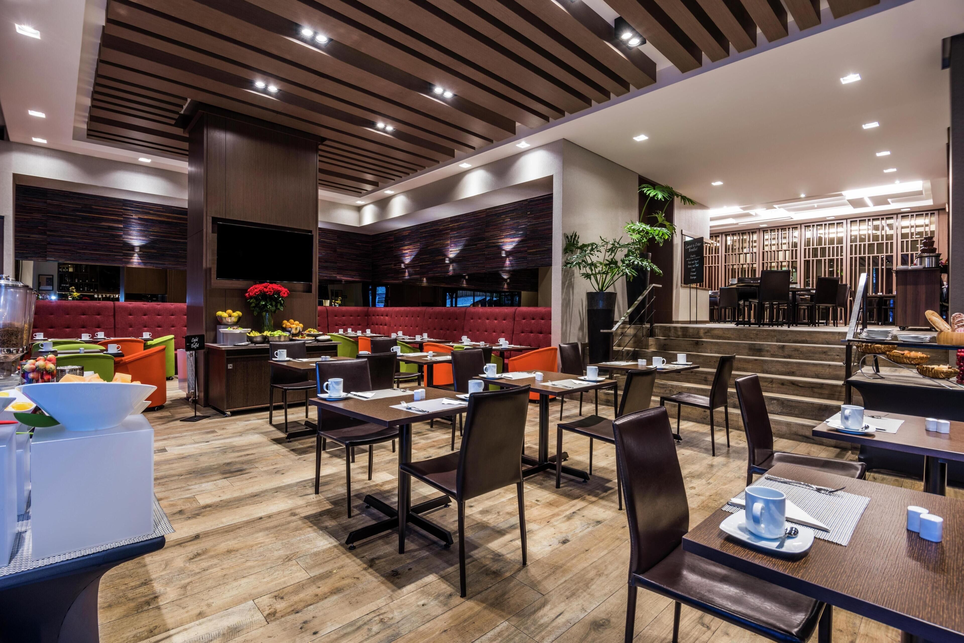 A modern restaurant with a variety of seating options, including booths and tables, and a bar area.