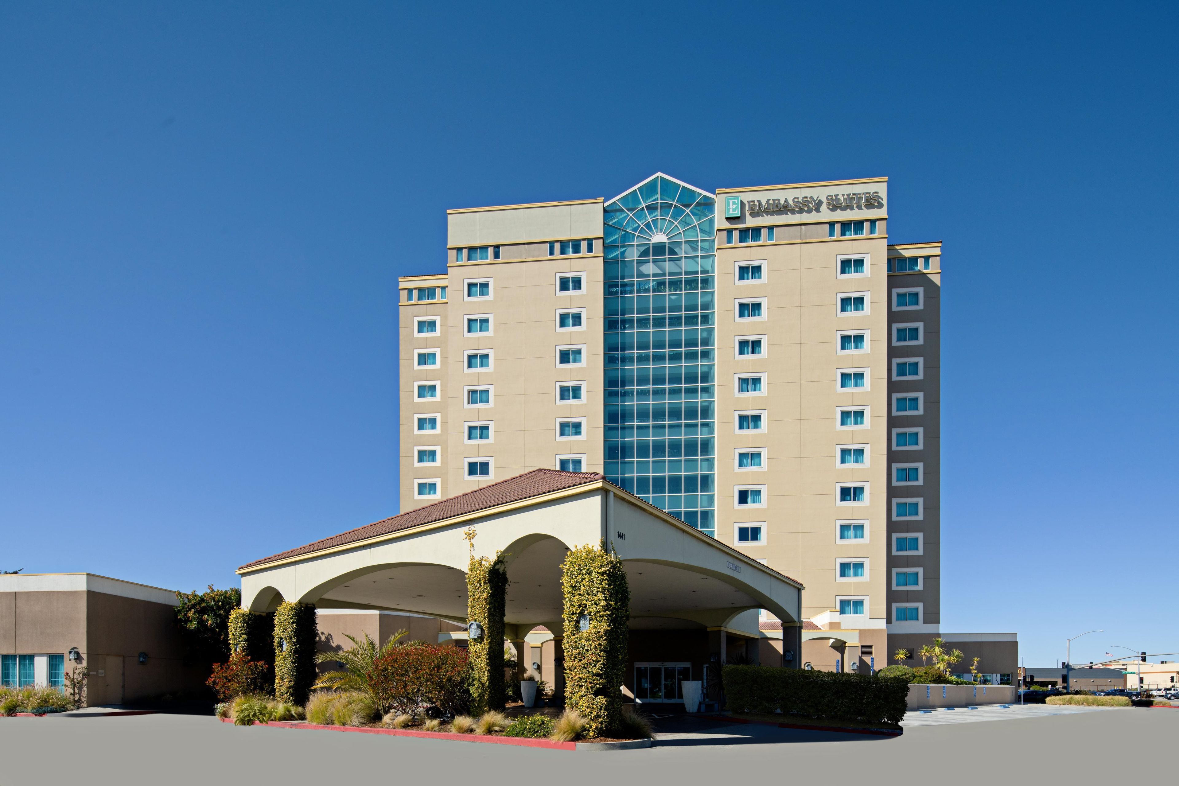 A hotel with a central atrium, multiple floors, and a prominent entrance with a covered area.