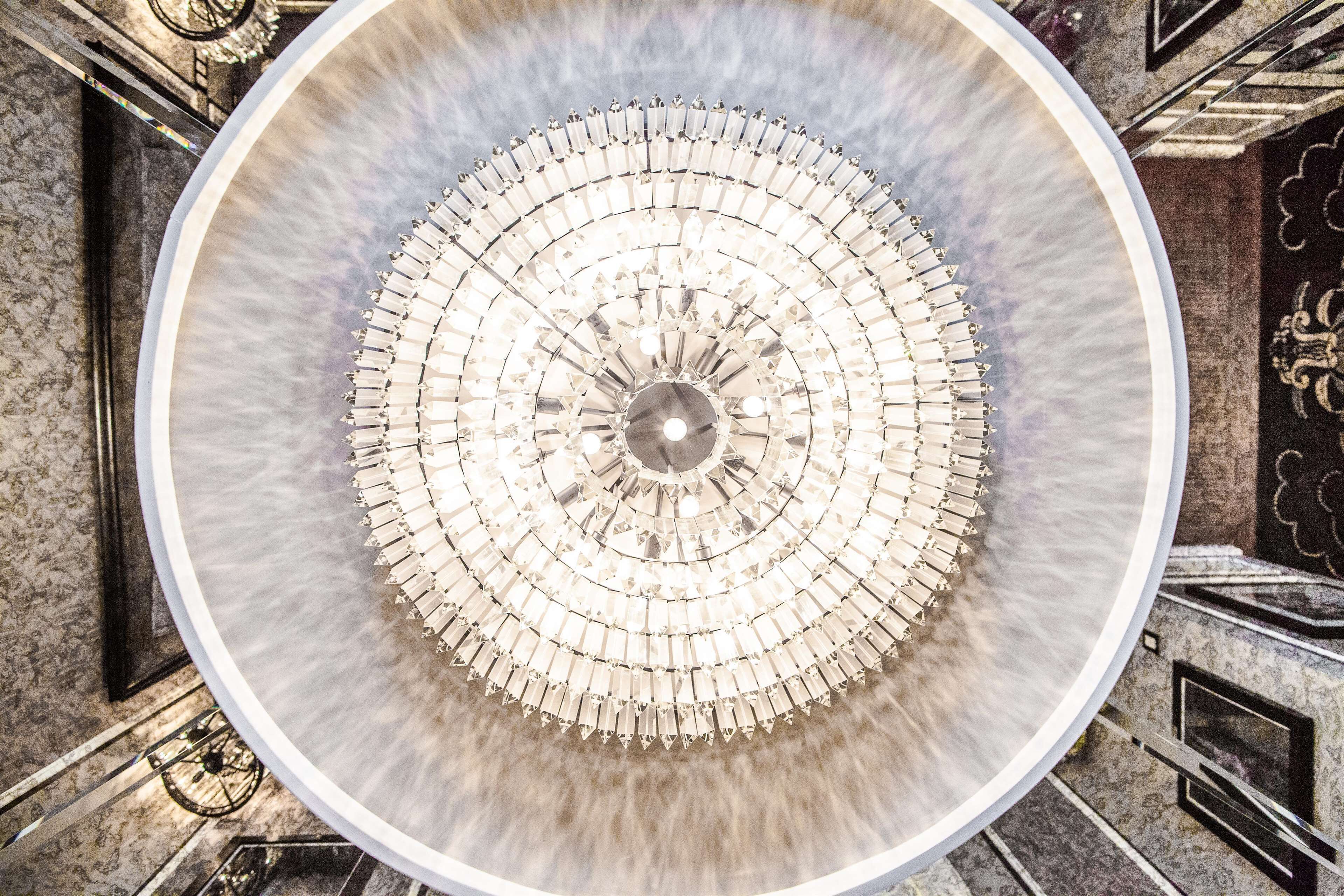 A circular chandelier with multiple tiers of crystal elements.