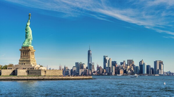 The Statue of Liberty and the New York City skyline across the water.